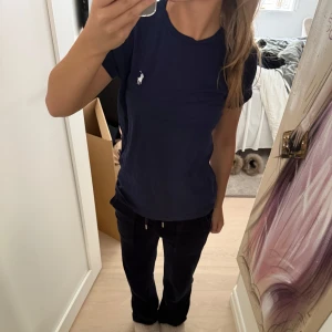 Mörkblå t-shirt från Ralph Lauren - Snygg mörkblå t-shirt från Ralph Lauren med klassisk vit logga broderad på bröstet. Ordinarie pris 600