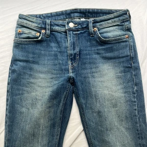 Blå Weekday jeans med slitna detaljer - Säljer ett par flame  jeans från weekday för att dom inte kommer till användning. Dom har en snygg tvätt, men dom har tyvärr ett litet hål vid slutet av benet för att dom var lite långa❤️W27 L32
