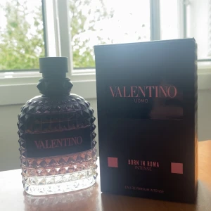 Valentino Born In Roma Intense EdP - Hejsan Valentino Born In Roma Intense Uomo Eau de Parfum. Flaskan är i glas med nitar och har en mörk, nästan svart överdel som övergår i transparent botten. Snygg svart och rosa etikett. Kommer med originalkartong i svart med rosa detaljer. Denna var inte min doft Används 5ml pris kan diskuteras med snabb affär
