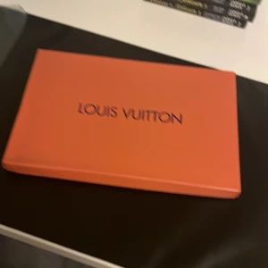 Louis Vuitton svart halsduk med monogram - Exklusiv svart halsduk från Louis Vuitton med ikoniskt monogrammönster i grått. Halsduken har en lyxig känsla och är perfekt för dig som vill sticka ut med en klassisk designeraccessoar. Kommer i originalask med tag kvar.
