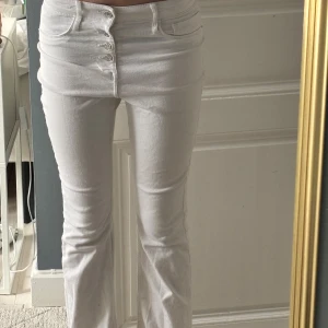 Vita bootcut jeans - Snygga vita bootcut jeans med hög midja men  man kan vika ner för mid rise och knappstängning. Perfekta för en stilren look. De har en klassisk design med fem fickor och är tillverkade i ett bekvämt material. De har fyra knappar. Storlek är 11-12 år. Fläcken på jeansen  kommer tvättas bort och ej synas❣️