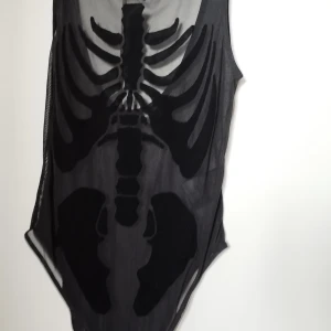 Mesh body med skelett ribcage - Cool svart mesh body från Divided med ett skelettmönster framtill. Tight passform och transparent material som ger edgy vibe. Perfekt för dig som vill sticka ut med en unik look.