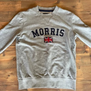 Grå Morris tröja  - Säljer en grå sweatshirt från Morris i storlek XS. Tröjan har stort Morris tryck på bröstet med den snygga Storbritanniens flagga nedanför. Jättestilig tröja. Ser ut som ny har inga tecken på användning, Jättebra skick. Pris är förhandlingsbart. Har du några frågor Hör av dig 🌟🌟🌟🙌🙌🙌🙌