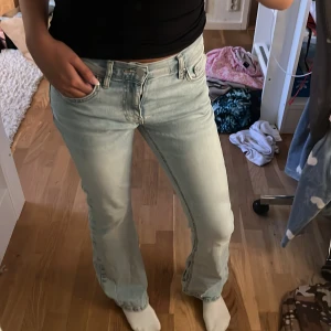 Ljusblå lowwaist bootcut jeans  - Säljer ett par ljusblå Ginatricot jeans med bootcut passform. Jeansen har klassisk femficksdesign, låg midja och är tillverkade i mjukt denim. Perfekta för dig som gillar en avslappnad men ändå snygg stil.