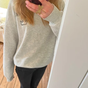 Grå sweatshirt med tryck - Säljer en grå sweatshirt med texten 'Ma Chérie' och en krona tryckt på baksidan. Tröjan har långa ärmar och en avslappnad passform. Perfekt för en casual look. Skriv vid frågor💓
