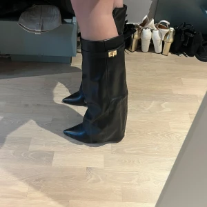 Svarta boots fold over - Supersnygga och trendiga fold over boots som endast är använda en gång! Jättesköna, men tyvärr liite för små i storleken för mig, så jag skulle säga att de är 39 och inte 40 i storleken som det stod när jag köpte de. Annars är de jättesköna att gå i. Hög (10cm) och tjock klack. Man kan även om man önskar dra in remsan med guld beroende på outfit och ens egna preferens som man kan se på bilderna.