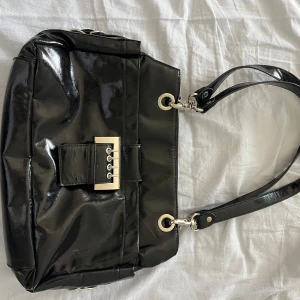 Svart handväska  - Säljer denna coola handväska i ”läder” med coola silverdetaljer. Använd en del men i väldigt bra skick!💕