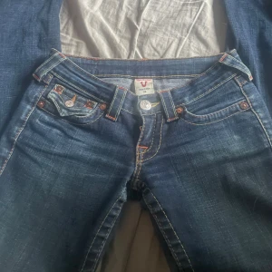 True Religion Jeans - Lågmidjade utsvängda raka jeans med slits. Storlek w24 