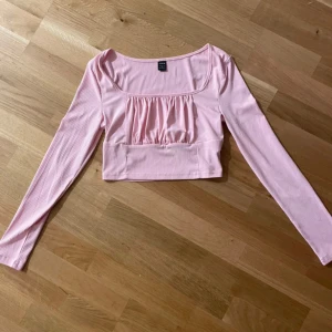 Rosa ribbad topp från Shein - Säljer en söt rosa ribbad topp från Shein. Toppen har långa ärmar och en fin rynkad detalj framtill. Perfekt för en trendig look! 💖