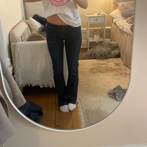 Mörkblå Lågmidjade jeans🥰🩷🙌 - Snygga mörkblå jeans från OKKO med en klassisk design. De har en låg midja och utsvängda ben, vilket ger en tidlös look. Jeansen har fram- och bakfickor samt kontrastsömmar som ger extra stil🩷🥰🙌
