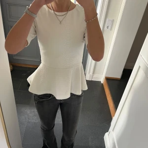 Vit volangtopp - Vit kortärmad tröja med volanger från H&M i storlek 36. Fint skick. Använd gärna köp nu!