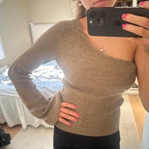 Guldglittrig oneshoulder topp - Snygg guldglittrig oneshoulder topp med lång ärm. Skitsnygg helt ny 