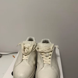 Vita sneakers från Eytys - Snygga vita sneakers från Eytys med en stilren design. Skorna har snörning och är tillverkade i skinn, vilket ger en lyxig känsla.Skorna är endast använda 3 gånger och har inga defekter. Mvh Eldin.