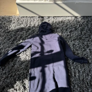 Mörkblå hoodie från GANT - Säljer en snygg mörkblå hoodie från GANT i storlek XS. Tröjan har en klassisk design med en stor ficka framtill och GANT-loggan tryckt på bröstet. Perfekt för en avslappnad stil. 