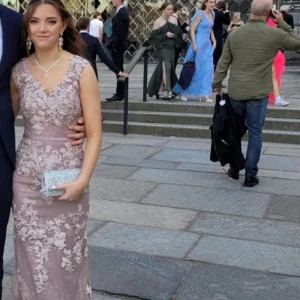 Ljuslila långklänning med spetsdetaljer - Elegant ljuslila långklänning med v-ringad hals och vackra spetsdetaljer. Klänningen har en figurnära passform och är perfekt för festliga tillfällen. Den är ärmlös och har en sofistikerad design som framhäver en feminin siluett.