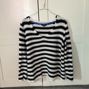 Svartvit randig tröja från H&M - Säljer en svartvit randig tröja från H&M. Tröjan har en v-ringad hals och långa ärmar, perfekt för en avslappnad stil. Den är tillverkad i ett mjukt material som känns skönt mot huden.