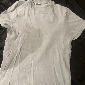 Ljusblå t-shirt från Zara - Säljer en stilren ljusblå t-shirt från Zara. Den är kortärmad och har en klassisk rund halsringning. Perfekt för en avslappnad look.