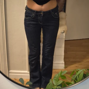 Mörkblå jeans med broderade fickor - Snygga mörkblå jeans med låg midja och broderade detaljer på bakfickorna. De har en klassisk bootcut-stil. På sista bilden kan du se en delat på en bakfick knapparna. Jag är 155cm.