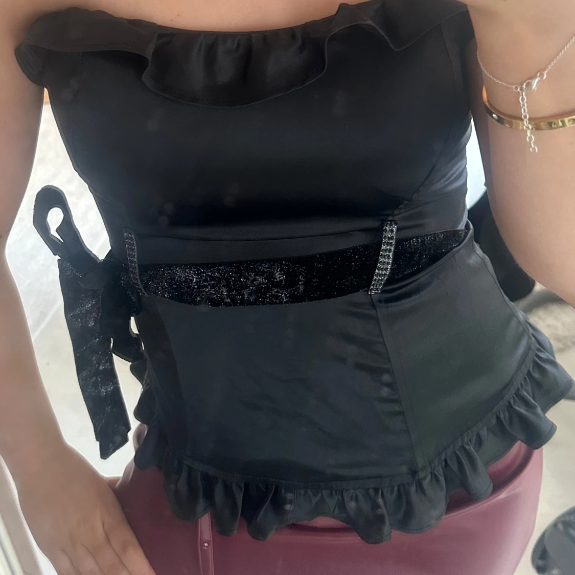 Svart axelbandslös topp med volangdetaljer - 1