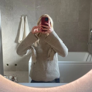 Stickad tröja med rosetter  - Beige mysig tröja med rosetter💕