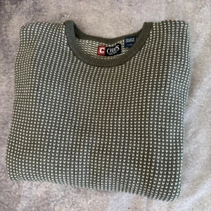 Grå och vit stickad tröja från Chaps - Säljer en snygg grå och vit stickad tröja från Chaps. Tröjan har ett diskret mönster och är tillverkad i 100% bomull. Perfekt för kyligare dagar med sin långärmade design och bekväma passform.