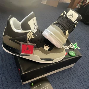 Nike Air Jordans 4  - Snygga Nike Air Jordans i svart och grått med vita sulor. Skorna har en ikonisk design med snörning och Jumpman-logga på plösen. Perfekta för sneakerheads som vill ha en klassisk stil. Helt oanvända Storlek 46.