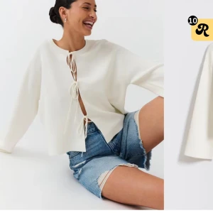 Vit tröja med knytning framtill - Säljer en stilren vit tröja med unik knytning framtill. Tröjan har långa ärmar och en avslappnad passform, perfekt för en trendig look. Passar bra till både jeans och kjol. Frakt tillkommer