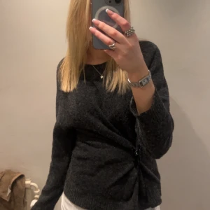 Mörkgrå stickad tröja - Säljer en populär mörkgrå stickad tröja från VeroModa.  Tröjan är i storlek M men skulle säga att den passar som storlek S bättre! Det är ett litet hål på höger axel, syns inte så mycket men är lätt att sy igen! Tvättas självklart innan postningen💕💕💕 (på första bilden har jag satt en hårklämma på tröjan!)