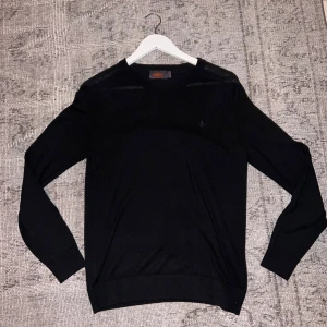 Merinoull tröja morris - Snygg svart merinoull tröja från Morris med rund hals och diskret logga på bröstet. Perfekt för en stilren look. Tröjan har långa ärmar och är tillverkad i ett mjukt material. Har ett pytte litet hål som knappt syns. Nypris 1300 Mitt: 300😛