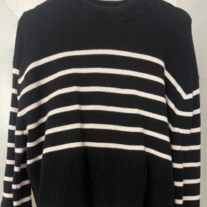 Svart och vit randig tröja från Gina Tricot - Säljer en snygg svart och vit randig tröja från Gina Tricot. Tröjan har långa ärmar och en ribbad rund halsringning. Perfekt för en stilren look. Passar bra till både jeans och kjol!