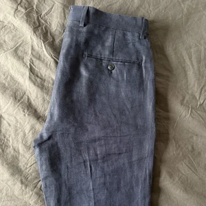 Mörkblå linnebyxor - Snygga mörkblå linnebyxor från MNG Man i en elegant och stilren design. Byxorna har en rak passform med knappdetalj bak och är tillverkade i ett bekvämt material. Perfekta för en dressad look. Aldrig använda (nypris 899!) 