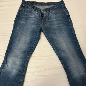 Blå jeans från Levi's - Säljer ett par klassiska blå jeans från Levi's med en snygg tvätt och femficksdesign. De har en knappgylf och är tillverkade i slitstarkt denim. Perfekta för en avslappnad stil. Storlek 37-38