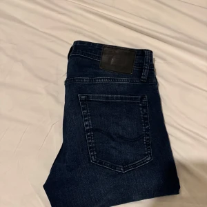 Mörkblå jeans från Jack n Jones - Snygga mörkblå jeans från Jack n Jones i modellen Glenn. De har en normal passform och är perfekta till exempelvis en schysst tisha och ett par snygga skor. Byxorna är i storlek 30/32. Vid frågor så är det bara att kontakta mig😊