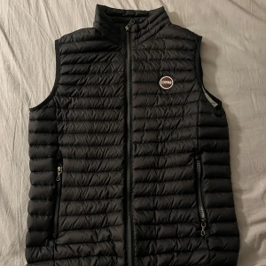 Svart dunväst från Colmar (nytt skick) - Säljer en svart dunväst från Colmar passar perfekt nu när det börjar bli lite varmare. Ny pris ca 2300.Västen är rett så ny använd ca 3-4 gånger så väldigt bra skick. Skriv om frågor eller fler bilder🙂Pris kan diskuteras litegrann.