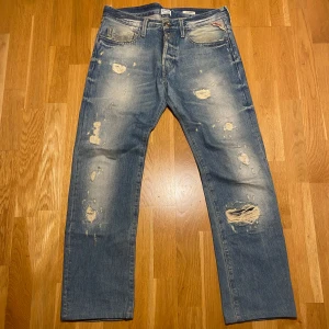 Feta Replay jeans - Snygga blå jeans från Replay med en galen tvätt. Perfekt för en grisch look.   Dom är uppsydda till längd 31 och passar 30 i midjan. Priset är inte hugget i sten