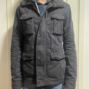 Fieldjacket - Superdry fieldjacket | storlek XS (personen på bilden är 169 och väger 52 kilo) skick 7,5/10 | fler frågor? Kontakta oss! |