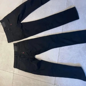 Blå jeans   - Snygga blå jeans med diskreta slitningar och en klassisk femficksdesign. Perfekta för en avslappnad stil.