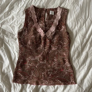 Mönstrad ärmlös topp med spetsdetaljer - Topp med paisleymönster och rosa spetsdetaljer. Storlek S