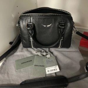 Zadig väska  - Kollar intresse på min iconic Zadig väska i modellen ”Sunny XS Studs Bag”, minimalistiska täcken på använding, så den är i sååå fint skick😍Dustbag & tags ingår utöver väskan (inks. De långa bandet) Nypris är 5 000kr och säljer min för 3600kr, priset går o diskuter lite