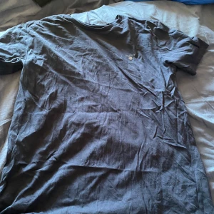 Mörkblå t-shirt från GANT - Säljer en stilren mörkblå t-shirt från GANT med broderad logga på bröstet. Perfekt för en avslappnad look. Passar dig som är 170 cm lång eller 15 år. Skön och enkel att matcha med det mesta. 💙Typ använt en sommar då jag inte klär mig i märkeskläder, en jätte fin tröja som jag hoppas någon annan får användning för.