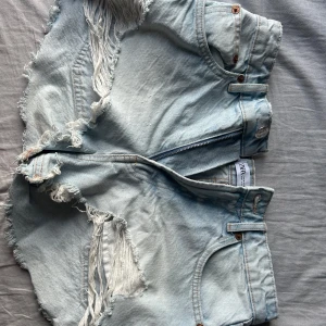 Zara jeansshorts  - Ljusblåa jeansshorts med slitningar som är perfekta till sommaren!! Storlek 38 men mindre i storleken.
