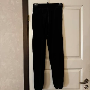 Svarta mjukisbyxor - Svarta mjukisbyxor med normal passform och resår i midjan. Perfekta för en avslappnad stil och bekväma att bära hela dagen. Klassisk modell utan synliga detaljer eller mönster.