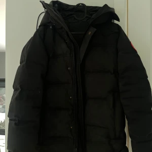 Svart dunjacka från Canada Goose - Säljer min svarta dunjacka från Canada Goose  använt den i 2 år, lite slit på jackan men går ändå att använda samt sy om man vill. Perfekt för kalla dagar. Äkta!  Ord ca 11.000