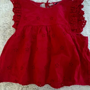 Röd volangblus med broderade detaljer från Zara - Supersöt röd blus från Zara med volangärmar och broderade blommor. Blusen har en luftig passform och knytning i nacken. Perfekt för dig som gillar färg och detaljer! 💕