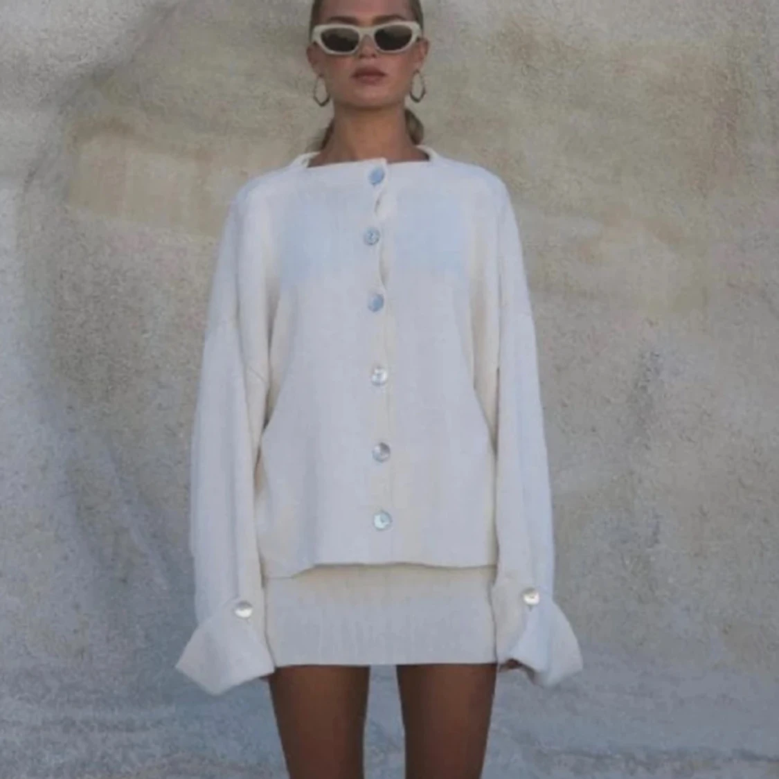 Krämvit kofta med pärlemorknappar