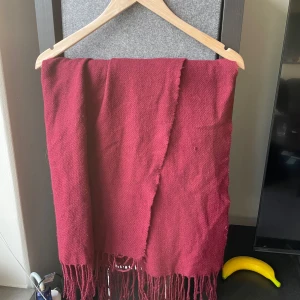 Vinröd halsduk med fransar - Lite sliten (se bilder).