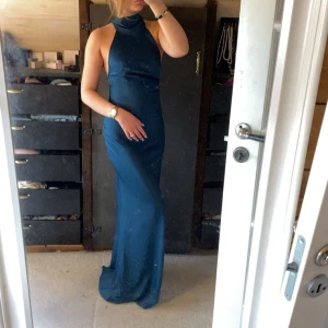 Mörkblå långklänning - Mörkblå långklänning med hög hals och öppen rygg. Helt ny med lappen kvar 💕 storlek 34💞