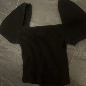 Svart ribbad topp med puffärmar - svart ribbad topp med stora puffärmar och fyrkantig halsringning. Croppad.