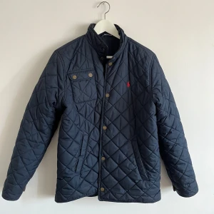Ralph Lauren Jacka   - En mörkblå Ralph Lauren jacka i storlek XL (18-20), men har passform som en herrjacka i storlek S. väldigt bra skick, fungerar i alla väder. 