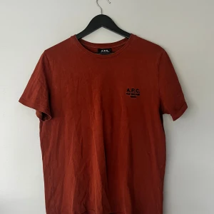 Apc t shirt  - Säljer en Apc t shirt i bra skick, är i en rost aktig färg och har mycket kvar att ge, priset är ej fast i sten.